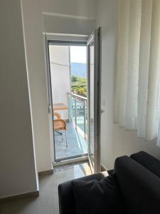 a living room with a door open to a balcony at Leo Apartments in Lezhë