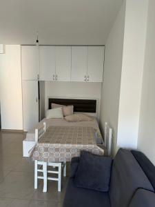 a bedroom with a bed and a table and cabinets at Leo Apartments in Lezhë