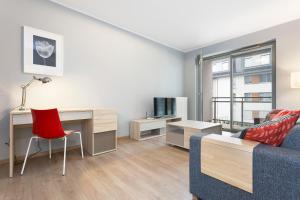 a living room with a couch and a desk at Spokojny i komfortowy apartament wśród zieleni in Wrocław