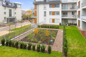 an apartment garden in front of a building at Spokojny i komfortowy apartament wśród zieleni in Wrocław