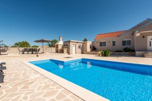 a swimming pool in front of a villa at Holiday Home Marija with pool in Buković