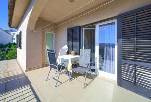a patio with a table and chairs on a balcony at Apartmani Kirinčić in Krk