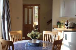 a kitchen with a table with a vase of flowers on it at The School House in Lochgilphead