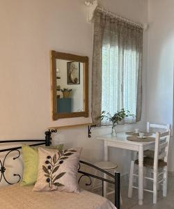 a bedroom with a table and a mirror and a bed at The Olive Studio by Yannula Studios in Kámpos