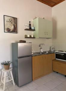 a kitchen with a refrigerator and a sink at The Olive Studio by Yannula Studios in Kámpos
