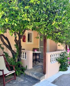 a garden with trees and a table and a chair at The Olive Studio by Yannula Studios in Kámpos +2 photos