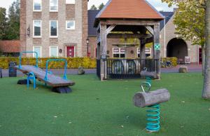 a park with a playground with a bench and swings at Othmar 't Lagerhuys - Groepsaccommodatie in Ootmarsum