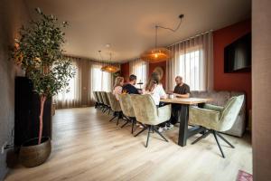 a group of people sitting at a table in a room at Othmar 't Lagerhuys - Groepsaccommodatie in Ootmarsum
