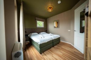 a small bedroom with a bed and a shower at Othmar 't Lagerhuys - Groepsaccommodatie in Ootmarsum