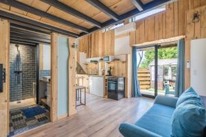 a living room with a blue couch and a kitchen at Le Cocon - Grospierres in Grospierres