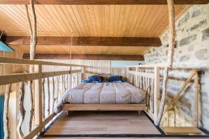 a bed in a room with a wooden ceiling at Le Cocon - Grospierres in Grospierres +16 photos