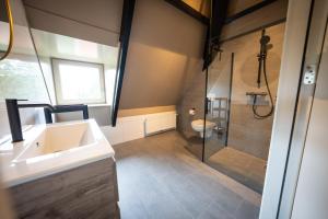 a bathroom with a shower and a sink and a toilet at Othmar 't Lagerhuys - Groepsaccommodatie in Ootmarsum +24 photos