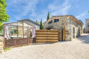 a building with a wooden gate and a glass house at Le Cocon - Grospierres in Grospierres
