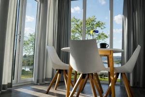 a table and two white chairs in front of a window at Odin Camping AS in Svensrud
