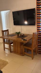 a wooden table with a television on a wall at African Treasure kokrobite in Kokrobite
