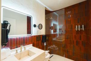 a bathroom with a sink and a shower with a mirror at YU Townhouse in Bodrum City +9 photos