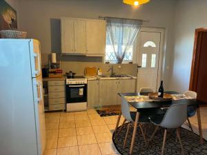 a kitchen with a table with chairs and a refrigerator at Maria's Apartment in Lixouri