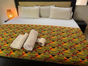 a bedroom with a bed with two towels on it at African Treasure kokrobite in Kokrobite +19 photos