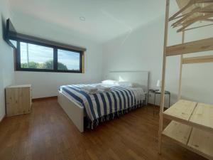 a bedroom with a bed and a large window at Quinta do Eirô in Fonte Arcada