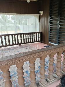 a wooden bench sitting in front of a window at Rooma Kayu in Kampong Alor Fatimah +1 photo
