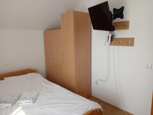 a bedroom with a bed and a tv on a wall at Vila Cezar in Gornja Toplica