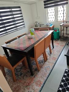 a kitchen with a wooden table and a dining room at Rooma Kayu in Kampong Alor Fatimah