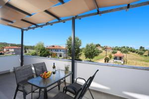 a patio with a table and chairs on a balcony at ELYSIAN luxury apartments in Paliouri