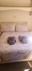 a bed with three pillows on top of it at 19 Vale Park in Fishguard