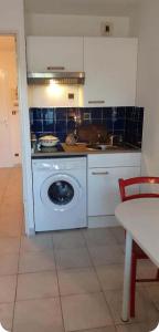 a kitchen with a washing machine in a kitchen at Plouf in Saint-Hilaire-de-Riez