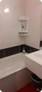 a bathroom with a white bath tub and a sink at Plouf in Saint-Hilaire-de-Riez