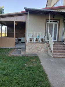 a house with a porch with two chairs on it at Casa Andrei in Haţeg