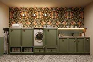 a laundry room with green cabinets and a washer and dryer at Bob W Vienna Döbling in Vienna