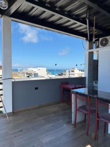 a patio with tables and chairs and a view of the ocean at La Casa D Juan in Puerto Baquerizo Moreno