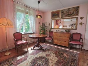 a living room with a table and chairs and a mirror at Artist eremitage Leonora - Historic schoolhouse apartment in Fjälkinge