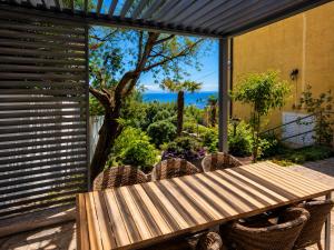 a table and chairs on a patio with a view of the ocean at Apartments and Rooms Vila Irma in Opatija
