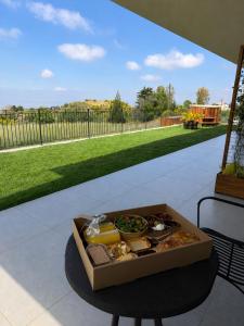 a box of food on a table on a patio at Calma Hermon Guest Rooms in Neve Ativ