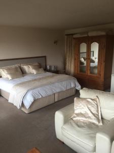 ein Schlafzimmer mit einem großen Bett und einem Sofa in der Unterkunft Ackroyd House in Holmfirth