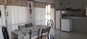 a table and chairs in a kitchen with a table and a refrigerator at La quinta de Hostal in Rosario