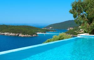 a swimming pool with a view of a body of water at White Orchid in Syvota