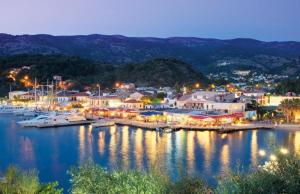 a harbor with boats in the water at night at White Orchid in Syvota +11 photos