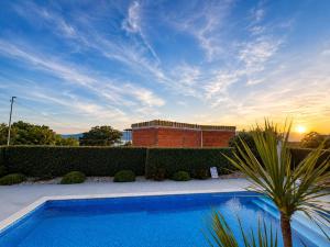 a swimming pool in front of a brick building at Luxury Villa Viktorija in Krk