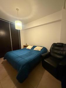a bedroom with a blue bed and a chair at General Acha 869 in San Juan