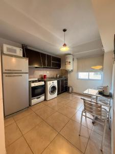 a kitchen with a white refrigerator and a table at General Acha 869 in San Juan