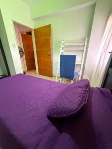 a bedroom with a purple bed and a blue chair at General Acha 869 in San Juan +3 photos