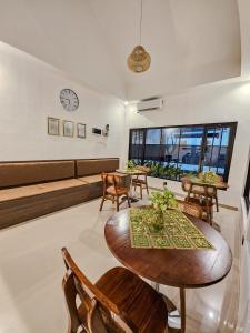 a living room with a table and chairs and a couch at Lodjisvarga Villa Yogyakarta in Sleman