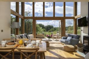 a living room with a table and a large window at The Tractor Shed in Combrook