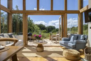 a living room with a large glass door at The Tractor Shed in Combrook