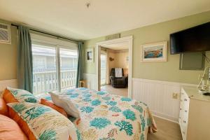 a bedroom with a bed and a tv and a balcony at Saltwater Breeze in Wells