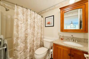 a bathroom with a toilet and a sink and a mirror at Saltwater Breeze in Wells +18 photos