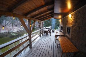 a porch of a cabin with a wooden bench and tables at Maxova Bouda in Josefŭv Dŭl